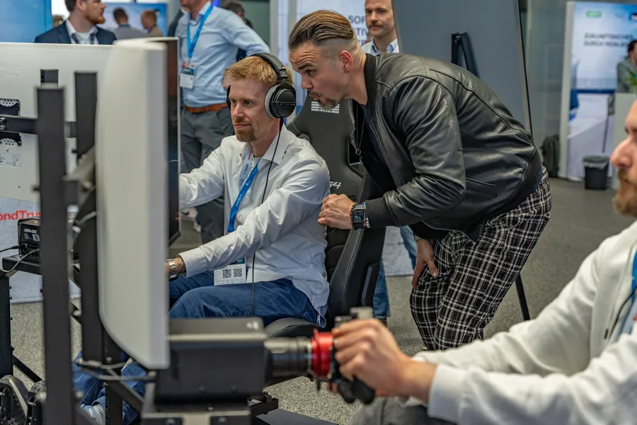 Zwei Personen am Motorsport-Simulator auf einem Corporate Event – intensiver Moment der Interaktion